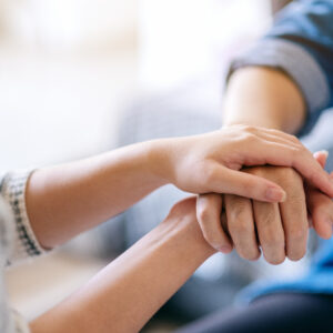 A man and a woman holding each other hands for comfort and sympa